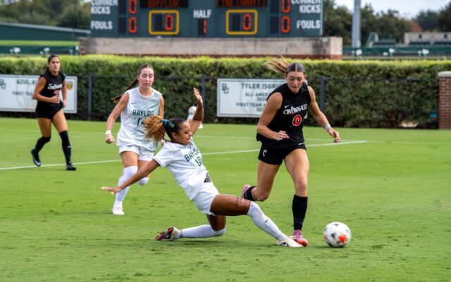 Senior Midfielder Aryanna Jimison slides to intercept a kick from a defender at the Cincinnati vs Baylor soccer game at the Betty Lou Mays Field Sunday. Caleb Garcia | Photo Editor