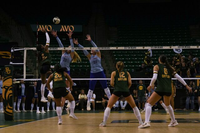 Pushing through the Kansas Jayhawks' attempt to block, sophomore outside hitter Bailey Warren goes for the kill. Mady Mijares | Photographer